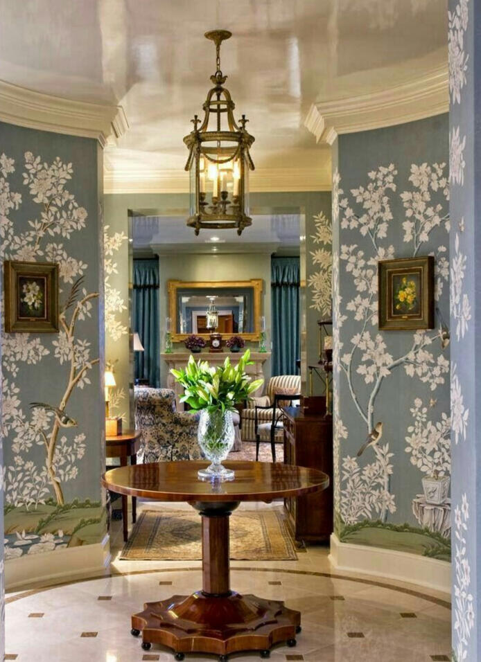 foyer with chinoiserie wallpaper and center hall table, with view to living room